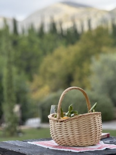 Wicker picnic basket on a rustic table with Croatian mountains behind