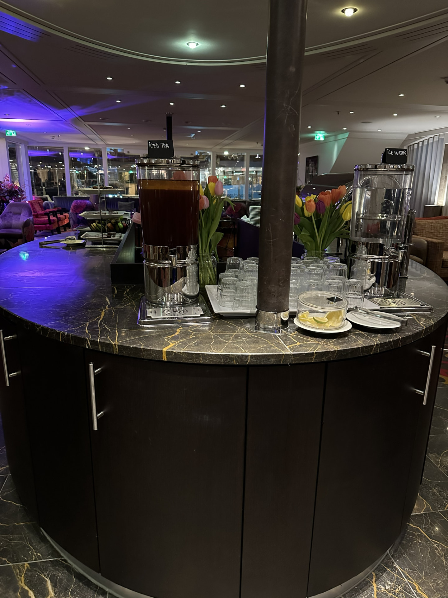 AmaSerena lounge refreshment station with iced tea, water, fresh tulips, and glassware