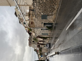 Rain-washed coastal road lined with stone houses in Croatia