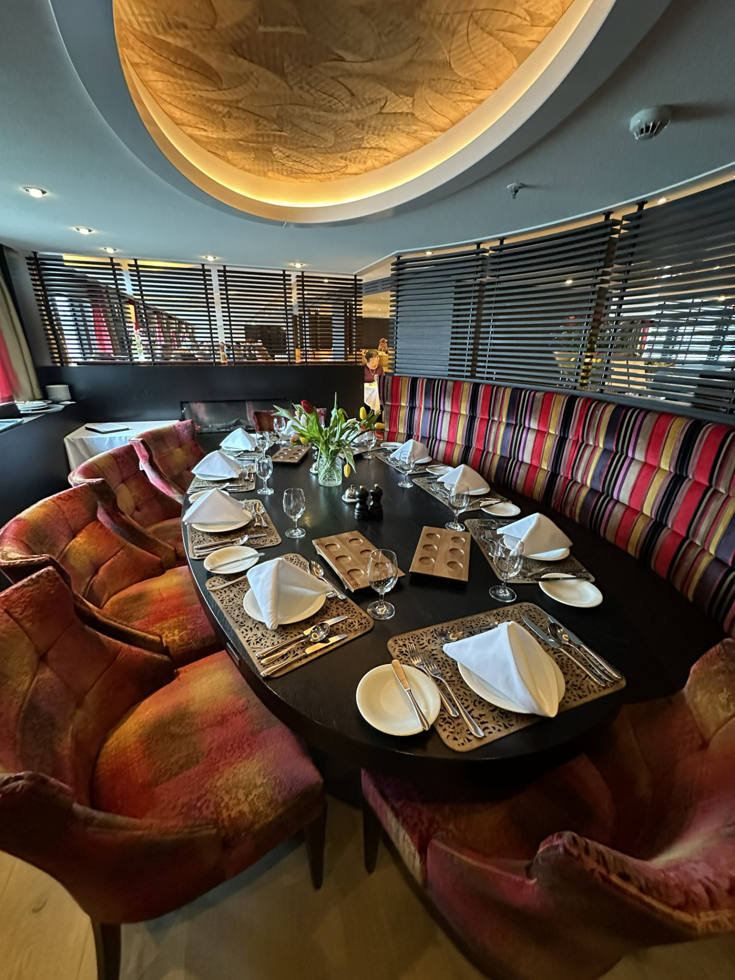 AmaSerena Chef's Table set for dinner with red upholstered seating and river views