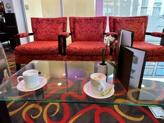 Red lounge chairs with coffee cups on a glass table aboard an AmaWaterways river cruise ship.