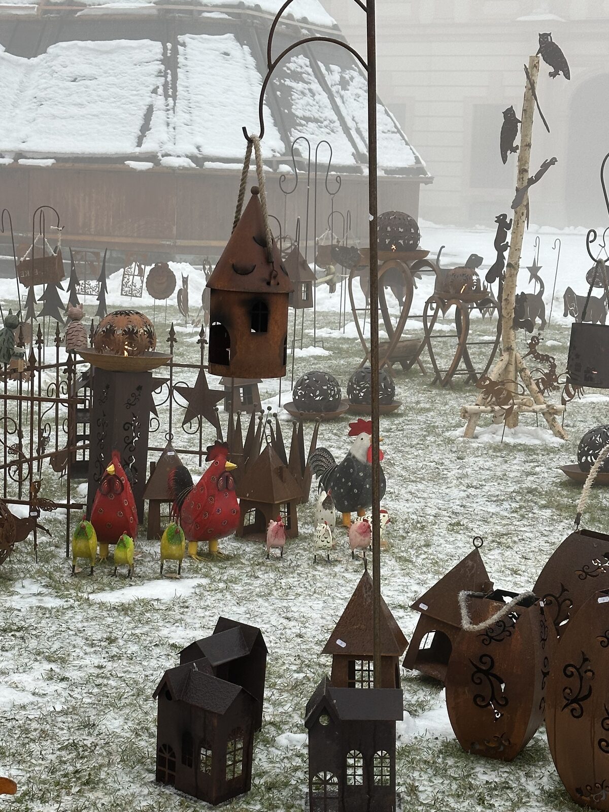Handmade metal lanterns and folk-art figures for sale at a snowy Christmas Market stall along the Danube, December 2024 river cruise