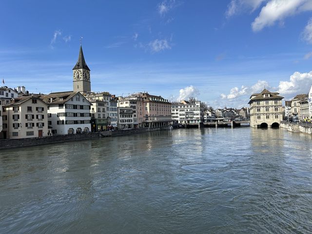 St. Peter's clock tower and pastel old-town buildings along the Limmat River in Zurich