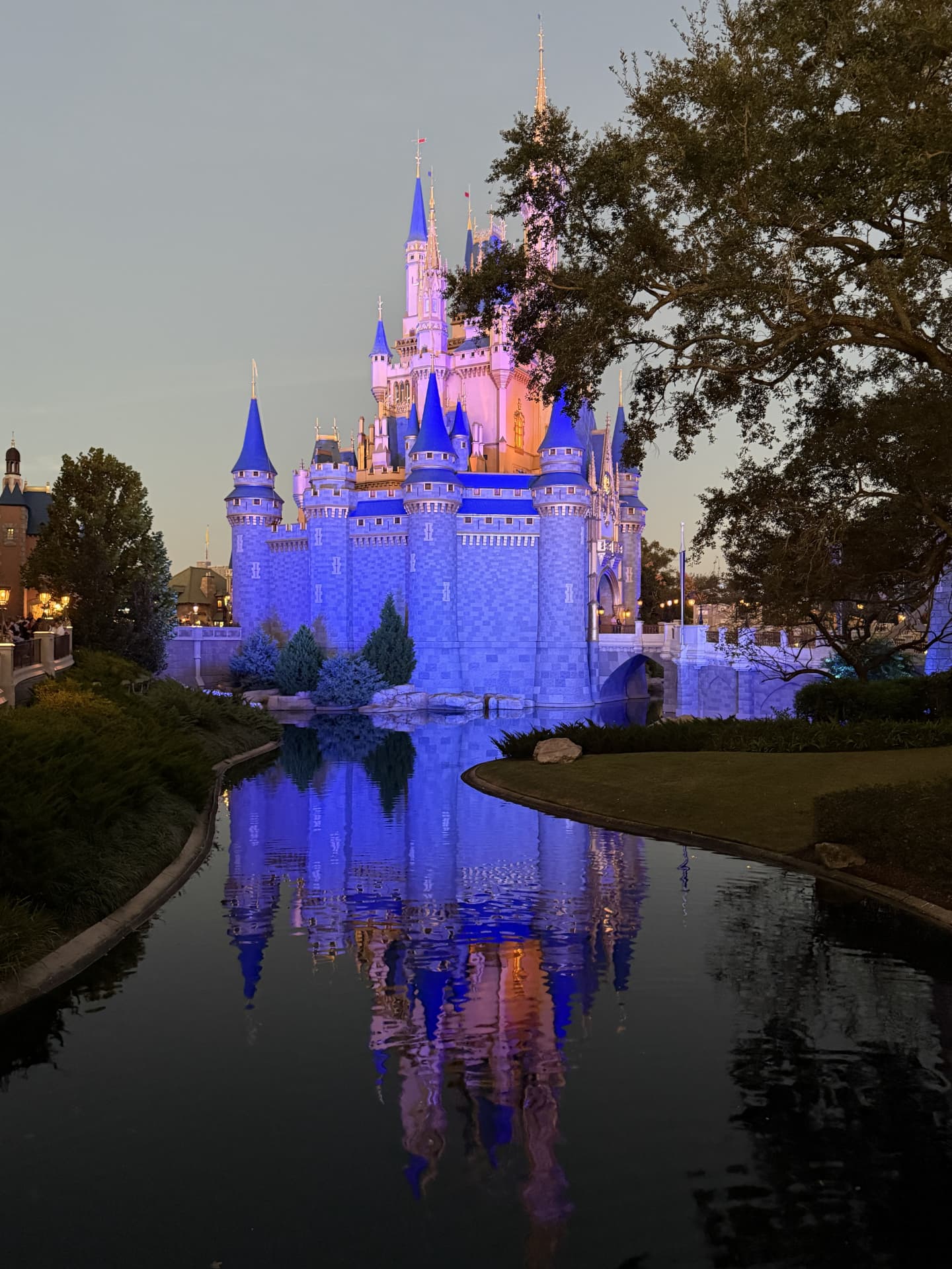 Cinderella Castle reflected in the water at Walt Disney World after sunset.